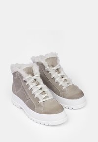Beige mokka korkeavartiset lenkkarit valkoisella tekoturkiksella vuorattuna, tasainen valkoinen kumipohja ja valkoiset nyörit. Jäykistetty päällinen ja sivusaumadetailit.