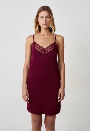 Burgundy slip dress in soft fabric with lace detailing along the neckline, featuring adjustable straps and a smooth, slightly curved hem.
