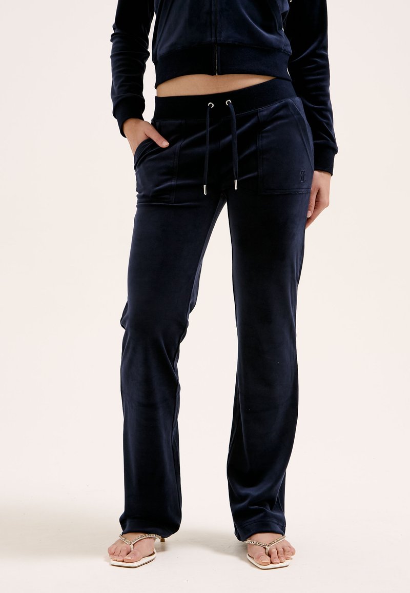 Marina velourbyxor i joggingstil med dragsko i midjan, sidofickor och raka ben. Slät textur med en subtil lyster.