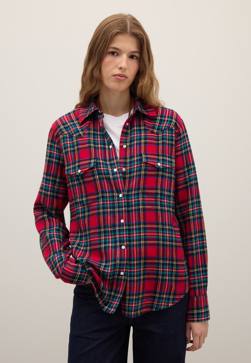 Red and blue plaid shirt in soft fabric, featuring a button-up front, two chest pockets, and a classic collar. Long sleeves with buttoned cuffs.