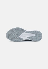 Semelle de chaussure présentant une surface en caoutchouc texturé, principalement grise avec un motif en diamant et un logo Nike blanc intégré dans le design.
