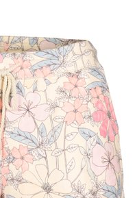 Joggers med blommönster mot en ljus krämfärgad bakgrund, med rosa och blå blommor, dragsko i midjan och mjuk tygstruktur.