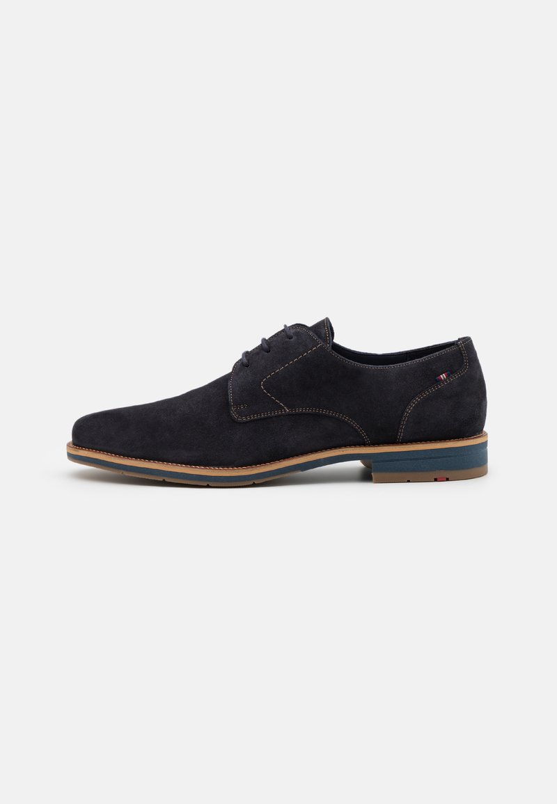 Dunkelblaues Wildleder-Dressschuh mit abgerundeter Spitze, gestickten Details und einer kontrastierenden hellbraunen Sohle. Schnürdesign mit minimalen Akzenten.