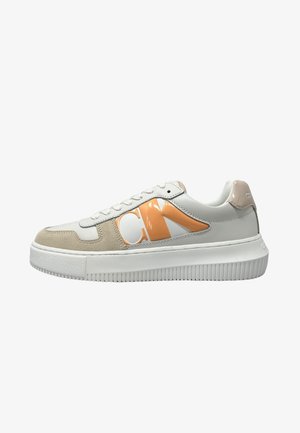 Sneaker bianco con accenti arancioni e beige, caratterizzato da una punta arrotondata, chiusura con lacci e suola in gomma texturizzata. Loghi sui lati.