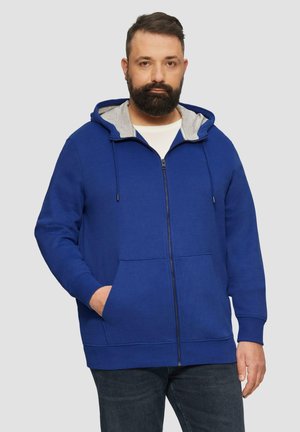 Blauwe ritshoodie met een grijs gevoerde capuchon, zijzakken en geribbelde manchetten. Gemaakt van zachte, duurzame stof met een comfortabele pasvorm.