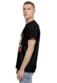 Black cotton t-shirt with short sleeves, featuring a colorful graphic print on the front, depicting a layered design with text.