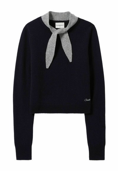 Pull cropped bleu marine avec un col en écharpe grise. Doté de poignets et d'un ourlet côtelés, fabriqué en tissu tricoté doux, avec un petit logo sur l'ourlet.