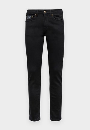 Czarne dżinsy z denimu o slim fit, pięcioma kieszeniami, złotymi akcentami i subtelną metką na przodzie. Gładka tekstura.