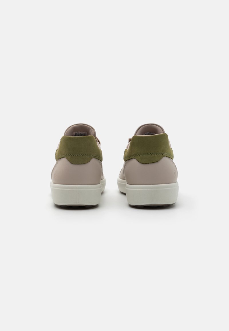 Sneaker mit einem glatten, hellbeigen Lederoberteil, olivgrünen Wildlederakzenten und einer weißen Gummisohle; abgerundete Ferse und genähte Details.