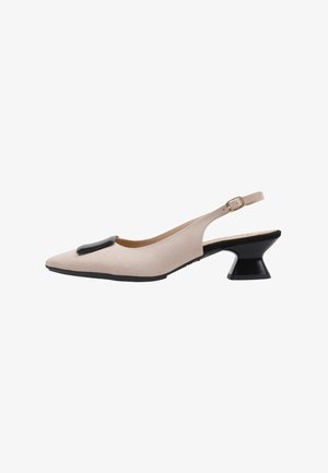 Zapato slingback beige puntiagudo con cuadrado decorativo negro en la parte delantera y tacón bajo, ancho y negro con hebilla en la correa del tobillo.