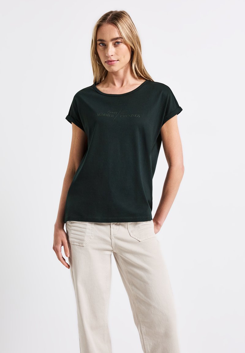 Mörkgrön t-shirt med korta rullade ärmar och rundad hals. Har präglad text "Sommarkvällar" framtill. Mjuk tyg.