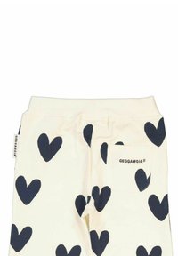 Korta leggings i krämfärg med marinblå hjärtan. Har en bakficka med logotyp och ett elastiskt midjeband för komfort.