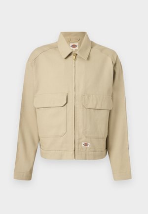 Bež jopič z zadrgo, z dvema velikima sprednjima žepoma s prekrivkama, ravnim ovratnikom, dolgimi rokavi in etiketo blagovne znamke Dickies na prsih ter robu.