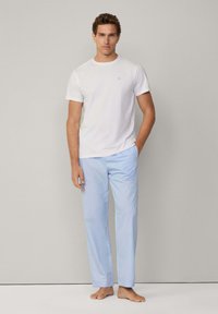 Camiseta blanca de manga corta combinada con pantalones rectos de color azul claro. Textura de tejido suave, diseño minimalista, sin patrones ni acentos visibles.