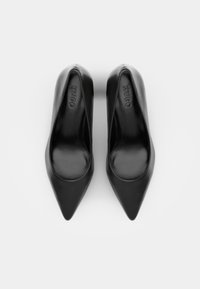 Tacchi alti neri a punta con una finitura in pelle liscia. Presentano una silhouette elegante e un discreto marchio impresso nella soletta.