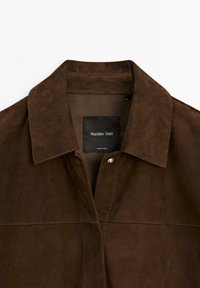 Brown suede jacket featuring a collar, visible stitching, and a tag labeled "Massimo Dutti" with "Made in India" at the bottom.