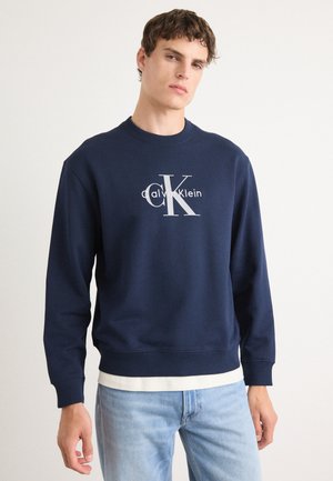 Marineblauwe sweatshirt van een katoenmix, met een ronde hals en ribgebreide manchetten. Groot logo aan de voorkant in contrasterend wit.