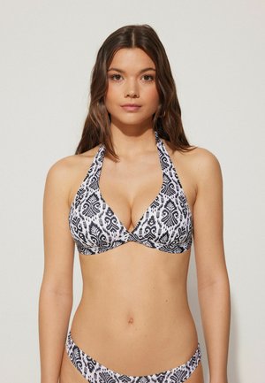 Top bikini a righe in bianco e nero con design a collo alto, dotato di scollatura profonda e texture di tessuto liscia.