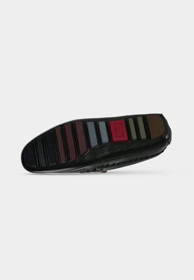 Semelle d'une chaussure en cuir noir avec des inserts en caoutchouc rectangulaires de plusieurs couleurs pour la traction et l'adhérence.
