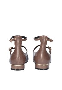 Zapatos de cuero marrón con tira al tobillo y un pequeño tacón, que cuentan con un acento dorado en la suela y un acabado suave. Diseño clásico con parte trasera cerrada.