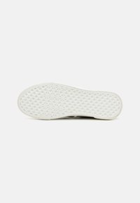 White rubber shoe sole with a textured diamond pattern. Edges are rounded, and the material appears durable with slight flexibility.
