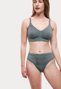 Grå sömlös bygelbehå och högmidjade trosor, gjorda av ett slätt tyg. Bygelbehån har justerbara axelband och en subtil V-ringning.