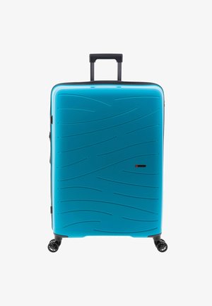 Valise rigide de couleur turquoise vif, présentant une surface texturée en vagues, une poignée rétractable et quatre roues pivotantes noires.