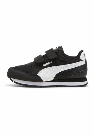 Zapatilla Puma en blanco y negro con dos tiras de velcro, logo Puma blanco en forma de franja en el lateral y suela de goma sobre fondo blanco.