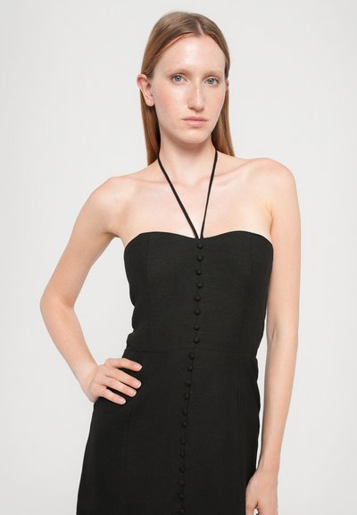 Black strapless dress with a fitted bodice, vertical button details down the front, and a soft, textured fabric. Halter neck design.