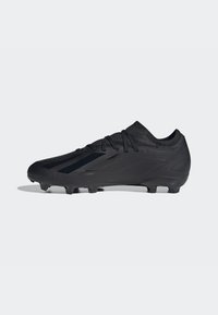 Scarpino da calcio nero con un design elegante, superficie testurizzata e lacci neri. Le caratteristiche includono un taglio basso e numerosi tacchetti sulla suola.
