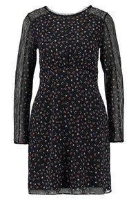 Schwarzes Kleid mit langen Spitzärmeln und einem Blumenmuster in Rot, Blau und Weiß. Die Taille ist gerafft für eine figurbetonte Silhouette.