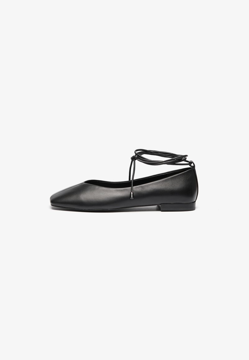 Balerini din piele neagră, cu vârf ascuțit, toc plat și detalii cu șireturi în jurul gleznei. Textură netedă, design minimalist.
