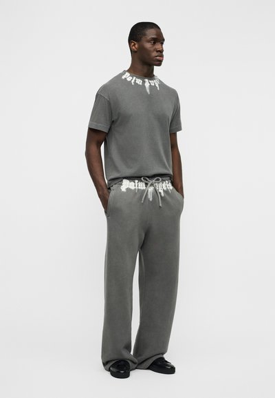 Γκρι βαμβακερό T-shirt με στρογγυλή λαιμόκοψη και λευκό γραφικό κείμενο, σετ με αντίστοιχο γκρι φόρμας με ελαστική μέση και κορδόνι.