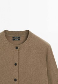 Brown cashmere cardigan with a round neckline, five black buttons down the front, and ribbed cuffs and hem. Soft texture and fitted design.
