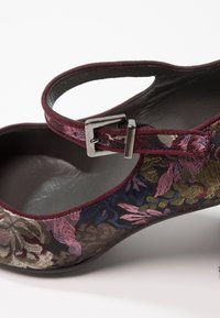 Chaussure Mary Jane brodée de fleurs en bordeaux avec bout pointu et bride ajustable à boucle argentée.