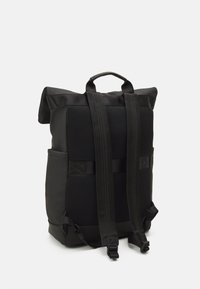 Zaino nero con design a roll-top, tessuto in rete e spallacci imbottiti. Presenta tasche laterali e spallacci regolabili per il trasporto.