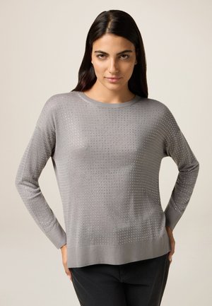 Pull gris clair à manches longues, présentant un motif texturé de petits trous, un col et un ourlet côtelés. Matière douce avec une coupe décontractée.