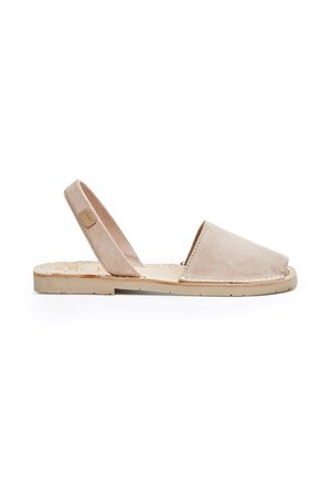 Sandalias de ante beige tipo slingback con puntera cerrada, suela de goma plana y detalles de costura mínimos. Textura suave y diseño sencillo.