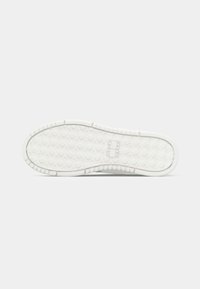White sneaker sole with a textured, hexagonal pattern. Features a thick rubber base and raised ridges for traction.