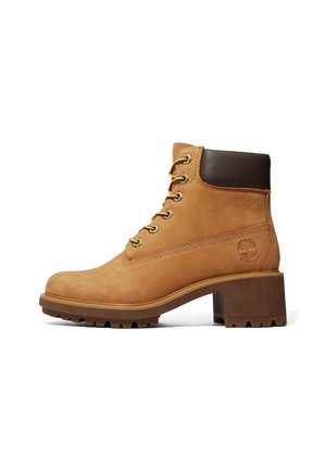 Bottine camel à lacets avec un col rembourré marron foncé, une semelle épaisse à crampons et un talon bloc, affichant le logo Timberland sur le côté.