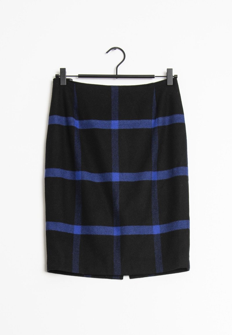 Jupe noire à motif écossais bleu suspendue à un cintre noir sur fond blanc.