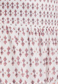 Kevyt kankainen mekko, jossa on röyhelöhelma, esittelee toistuvaa geometrista kuviota vaaleanpunaisen, purppuran ja valkoisen sävyissä. Pintakuviointi koko mekossa.