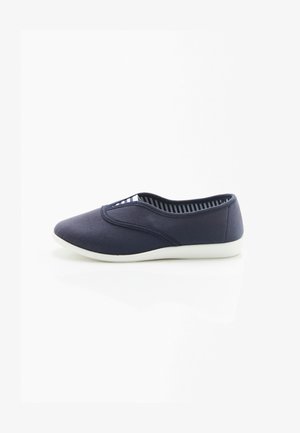 Zapatos náuticos de lona azul marino tipo slip-on con puntera redonda, detalles elásticos y suela de goma blanca. El interior presenta un patrón de rayas azul marino y blanco.