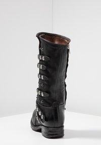 Czarne skórzane buty z wysoką cholewką, zapinane na zamek, z licznymi metalowymi detalami po boku. Solidna podeszwa o textured wykończeniu.