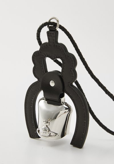 Svart läderaccessoar med en dekorativ scallopform och en silverklocka. Har ett flätat rem och silverdetaljer.