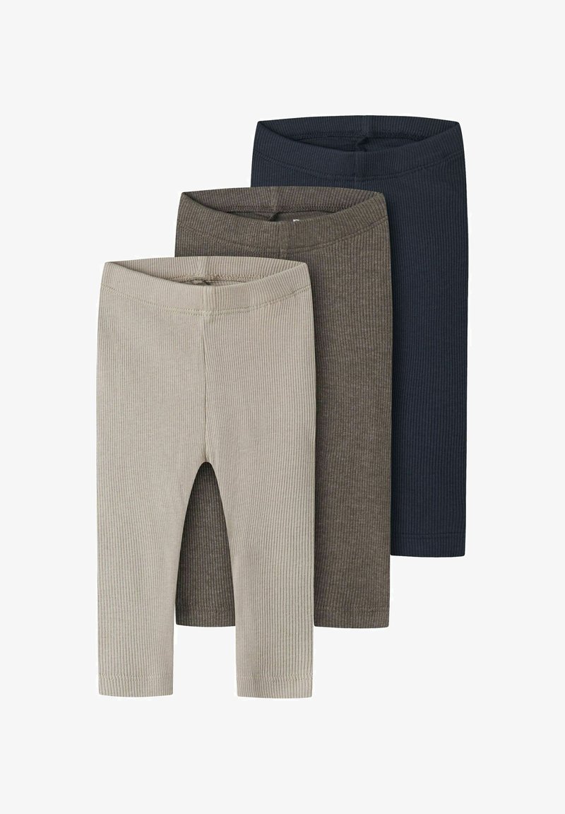 Trois paires de leggings en maille côtelée beige, marron et bleu marine, empilées verticalement avec les ceintures élastiques visibles.