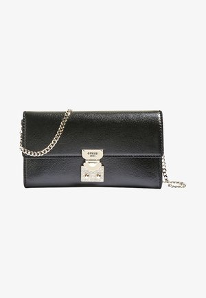 Pochette Guess en cuir noir avec chaîne argentée et fermoir argenté gravé "GUESS 1981".