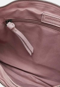 Interno morbido di colore rosa di una borsa con una tasca con zip e tirazip in pelle. Il tessuto è liscio, con sottili dettagli di cucitura e senza fantasie.
