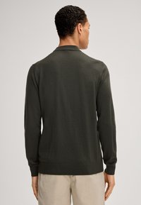 Dunkelgrüne Strickjacke mit langen Ärmeln, gerippten Bündchen und Saum sowie einem einfachen Kragen. Glatte Textur und taillierte Passform.