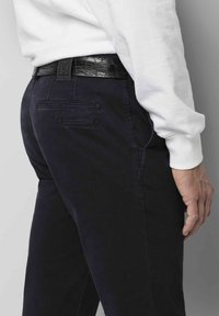Marinefarbene Hose im Slim Fit, gefertigt aus weichem Stoff. Verfügt über zwei Gesäßtaschen, Steppdetails und einen schwarzen strukturierten Gürtel.